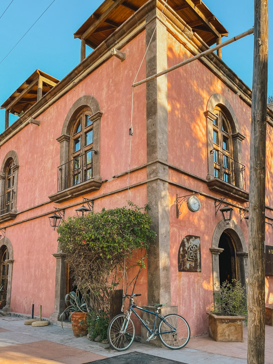 Bâtiment rose de style colonial avec un vélo dans la ville de Loreto - Nomade Amoureux
