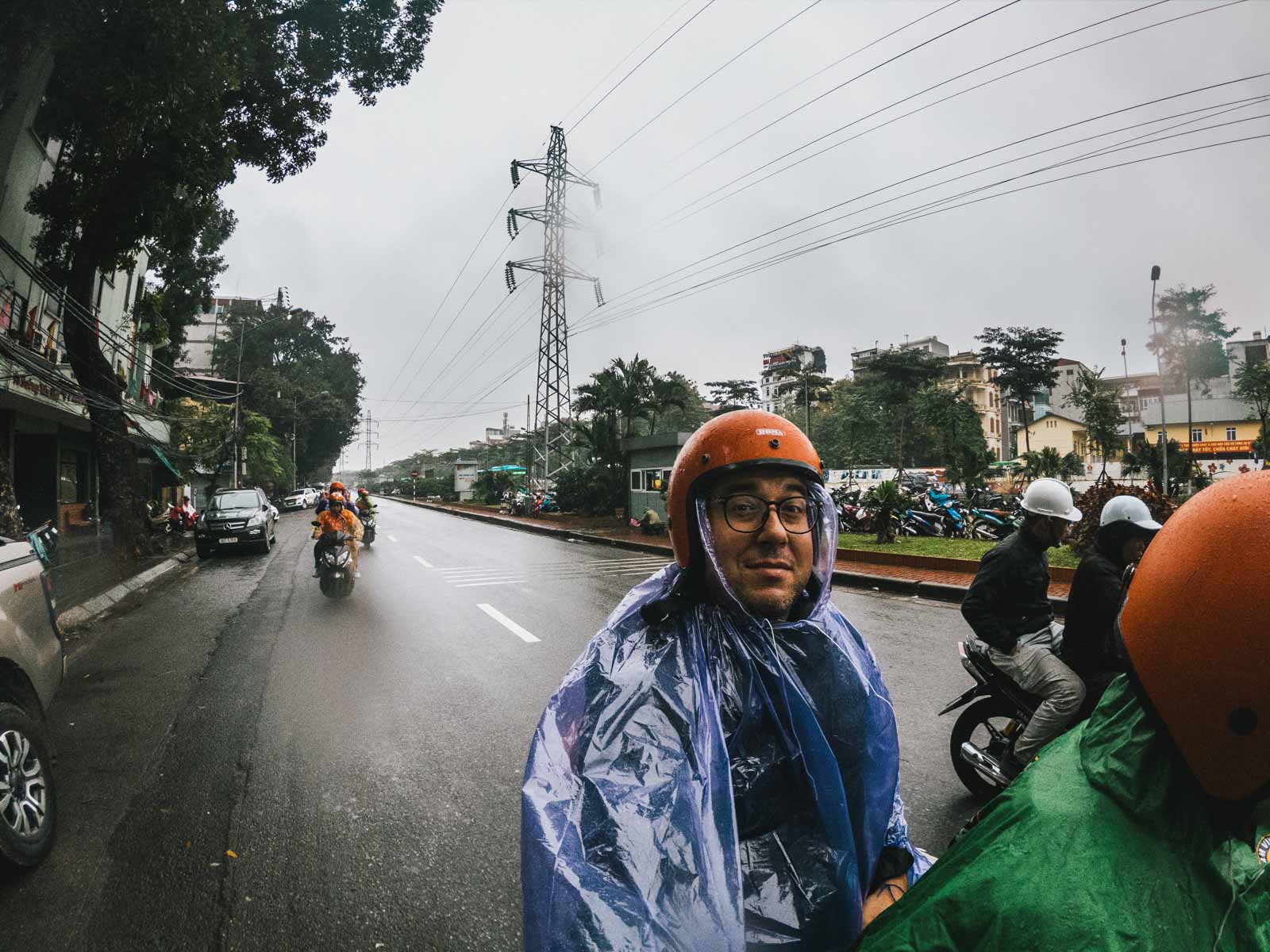 Un homme en scooter pendant la saison des pluies au Vietnam - astuces pour préparer son voyage